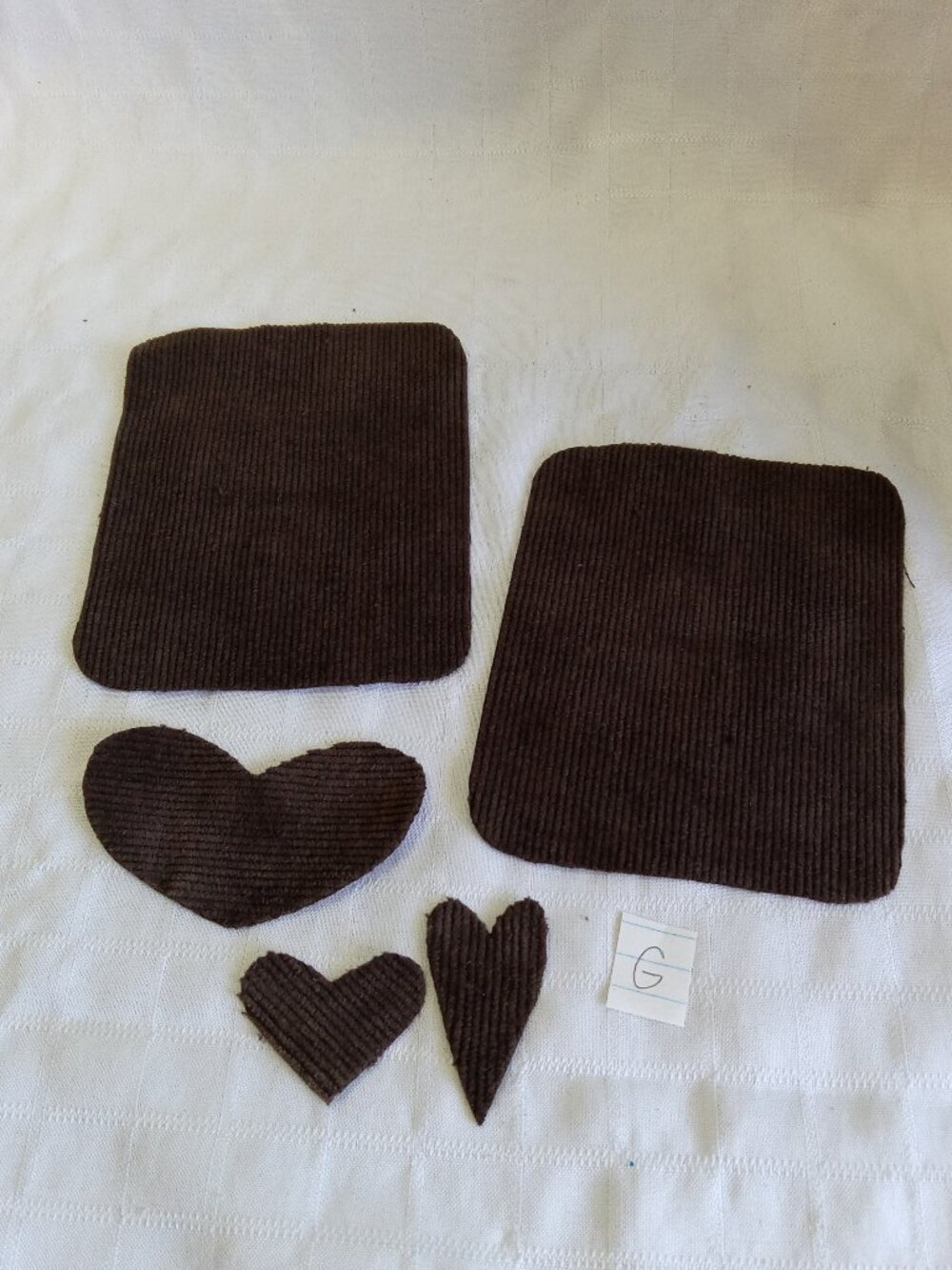Two handmade elbow patches for sewing made of brown corduroy with hearts
